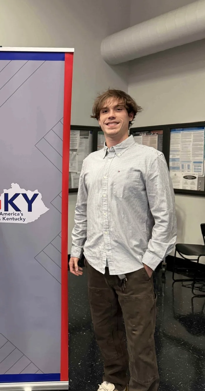 Hunter standing beside a Jobs for America’s Graduates Kentucky event banner.